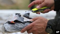 FILE - National Police Chief Gen. Rodolfo Palomino opens a package of seized cocaine to show to the press at a police station in Necocli, Colombia.