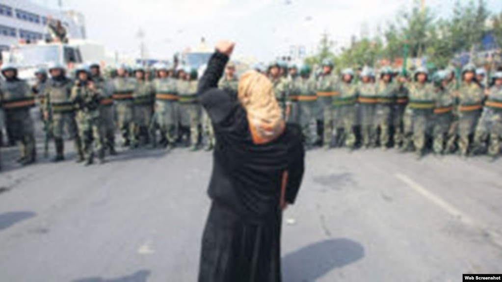 资料照：一名新疆维吾尔妇女举拳向一队中国武警士兵表示抗议。(照片来自世界维吾尔代表大会网站)(photo:VOA)