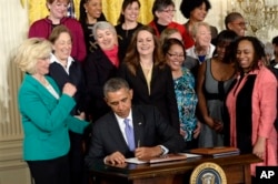 FILE - President Barack Obama signs executive actions, with pending Senate legislation, aimed at closing a compensation gender gap that favors men during an event in Washington marking Equal Pay Day, April 8, 2014.