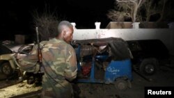 2016年8月25日一名索马里警察在查看在海滩餐厅汽车炸弹中摧毁了的车辆的残骸。