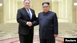 Le dirigeant nord-coréen Kim Jong Un et le secrétaire d'Etat américain Mike Pompeo dans une photo publiée le 9 mai 2018 par l'Agence de presse coréenne du nord (KCNA) à Pyongyang.