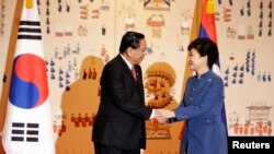 လာအိုသမ္မတ Choummaly Sayasone (ဝဲ) နှင့် တောင်ကိုရီးယားသမ္မတ Park Geun-hye တို့ တောင်ကိုရီးယားနိုင်ငံ၊ သမ္မတအိမ်တော်မှာ တွေ့ဆုံကြစဉ်။ (နိုဝင်ဘာ ၂၃၊ ၂၀၁၃)