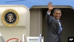 President Barack Obama waves from the top of the steps of Air Force One at Andrews Air Force Base, on his way to Martha's Vineyard for vacation, Aug. 18, 2011