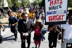 Cornel West, second from left, walks in a march against racism and injustice before the Republican National Convention in Cleveland, Ohio, July 16, 2016.