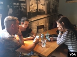 A father and his two daughters take a break from sightseeing at a Starbucks in Washington, D.C. (C. Maddux/VOA)