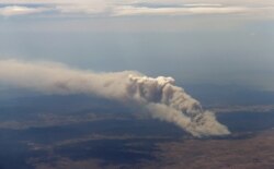 FILE - Smoke rises from the Yarrabin bushfire, burning out of control near Cooma, about 100 kilometers south of Canberra, Australia, Jan. 8, 2013.