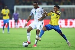 L'attaquant ghanéen Jordan Ayew (à g.) se bat pour le ballon avec le défenseur gabonais Johann Obiang au Stade Ahmadou Ahidjo à Yaoundé le 14 janvier 2022.
