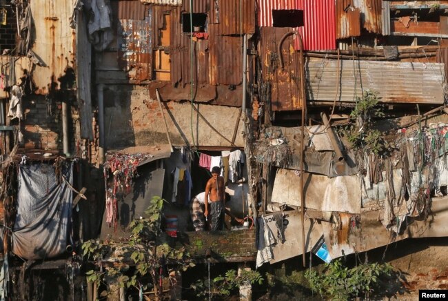 A man brushes his teeth outside a shanty in Dharavi, one of Asia's largest slums, in Mumbai, India, Dec. 27, 2016.