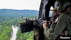 Venezuelan soldiers watch from the door of a helicopter as they patrol during a military operation to destroy clandestine drug laboratories, near the border with Colombia, in the state of Zulia, Dec. 6, 2014.