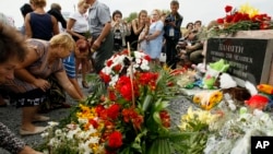 Local residents lay flowers to commemorate victims of the Malaysian Airlines plane, near the village of Hrabove, Donetsk region, eastern Ukraine, July 17, 2017. 