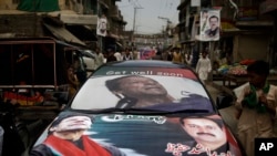 Pakistani supporters of former cricket star-turned-politician, and leader of Pakistan Tehreek-e-Insaf party, Imran Khan, ride a car decorated with his Khan's pictures, near a polling station in Rawalpindi, Pakistan, May 11, 2013.