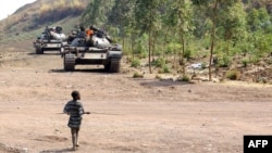 Young boy walks toward FARDC government forces tanks near the front line in Kanyaruchinya, 15 km from Goma, DRC, July 24, 2013.