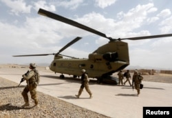 FILE - U.S. troops walk from a Chinook helicopter in Uruzgan province, Afghanistan, July 7, 2017.