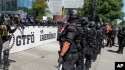 Portland police keep Patriot Prayer affiliates separate from antifa protesters during a rally in Portland, Ore., Saturday, Aug. 4, 2018.Small scuffles broke out Saturday as police in Portland, Oregon, deployed "flash bang" devices and other means to disperse hundreds of right-wing and self-described anti-fascist protesters.