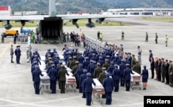 FILE - Military personnel unload a coffin with the remains of Brazilian victims who died in a plane crash in the Colombian jungle with Brazilian soccer team Chapecoense.