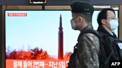 人们走过首尔一处火车站显示朝鲜试射导弹新闻的电视屏幕。(2022年1月11日)