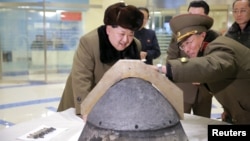  North Korean leader Kim Jong Un looks at a rocket warhead tip after a simulated test of atmospheric re-entry of a ballistic missile, at an unidentified location in this undated photo released by North Korea's Korean Central News Agency (KCNA).