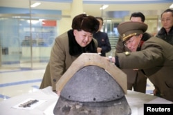 FILE - North Korean leader Kim Jong Un looks at a rocket warhead tip after a simulated test of atmospheric re-entry of a ballistic missile, at an unidentified location in this undated photo released by North Korea's Korean Central News Agency.