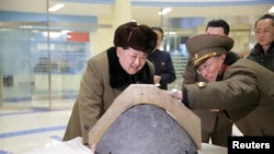 FILE - North Korean leader Kim Jong Un looks at a rocket warhead tip after a simulated test of atmospheric re-entry of a ballistic missile, at an unidentified location in this undated photo released by North Korea's Korean Central News Agency.