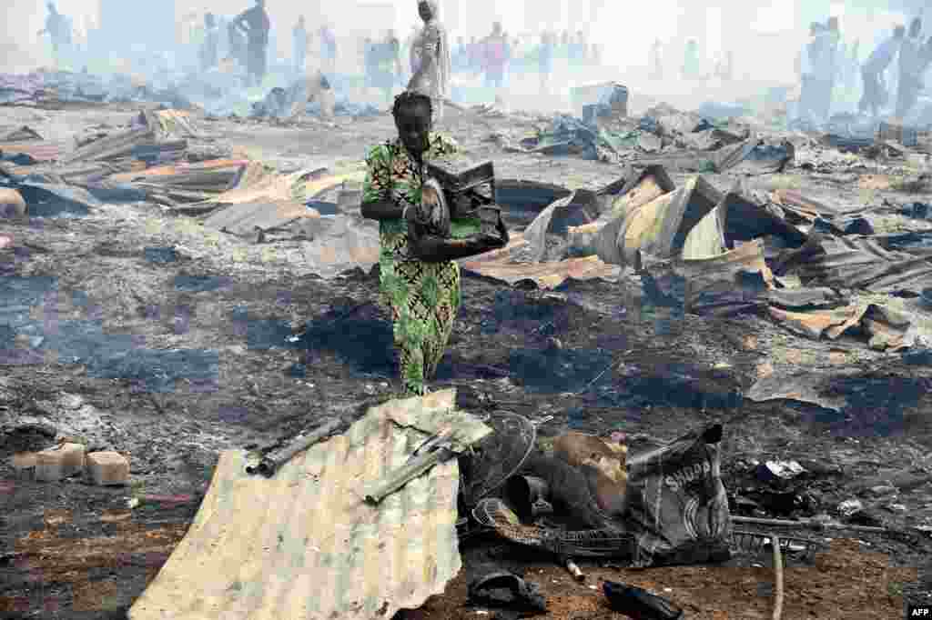 A local resident attempts to salvage a stove from the fire in the biggest Lagos wood market, Oko-Baba Sawmill, in Ebute-Metta, district of Lagos, Nigeria.