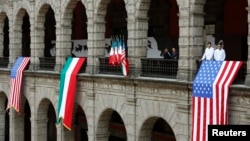 FILE - U.S. and Mexican flags are displayed at the National Palace in Mexico City, May 2, 2013. 