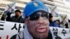 A protester wearing a mask depicting former U.S. basketball star Dennis Rodman, attends a rally in central Seoul, South Korea, Jan.8, 2014, denouncing Rodman's visit to North Korea and North Korean leader Kim Jong Un on Kim's birthday. 