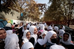 Siswa sekolah dasar perempuan meninggalkan sekolah mereka usai mengikuti pelajaran di kelas mereka di Kabul, Afghanistan, 25 Oktober 2021. (REUTERS)
