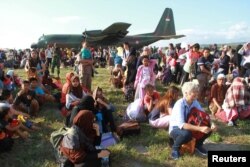 Local residents affected by the earthquake and tsunami wait to be airlifted out by military planes at Mutiara Sis Al Jufri Airport in Palu, Central Sulawesi, Indonesia, Sept. 30, 2018, in this photo taken by Antara Foto.