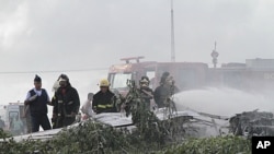 Firemen spray fire retardant on plane L410 of Noar Airlines that fell near Boa Viagem beach in Recife, the capital of the northeastern state of Pernambuco, July 13, 2011