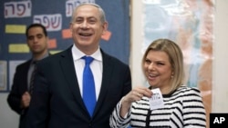 FILE - Israeli Prime Minister Benjamin Netanyahu stands by his wife Sara as she casts her ballot at a polling station in Jerusalem, Jan. 22, 2013.