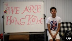 FILE- A member of the CUHK student union poses in front of a whiteboard kept in the student union offices with writing that says "We Are Hong Kong" at the Chinese University Hong Kong (CUHK) campus, September 20, 2017. 