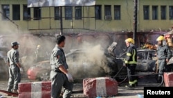 Afghan policemen inspect the site of a blast in Jalalabad city, Afghanistan, July 1, 2018. 