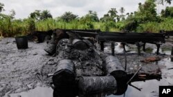 FILE- An abandoned illegal refinery is seen after it was raided by the Nigeria navy at the creeks of Bayelsa, Nigeria, May 18, 2013. At the time, the navy said it had destroyed 260 illegal refineries and burned 100,000 tons of contraband fuel to try to halt oil thefts bedeviling the economy of Africa's biggest petroleum producer.