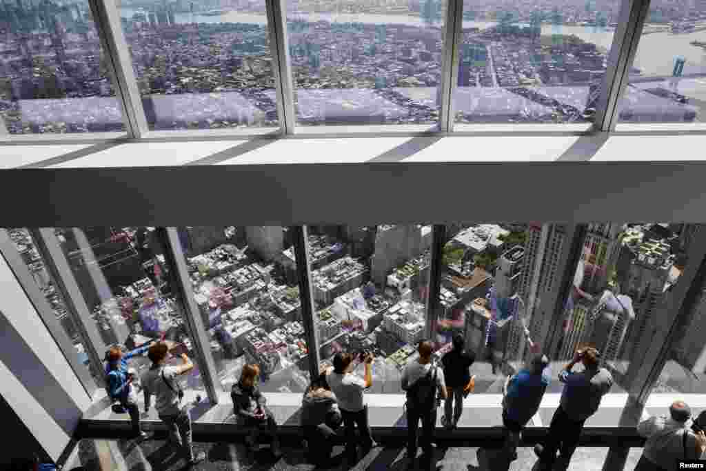 Visitors take photos at the newly opened One World Observatory in New York. Taking up parts of the 100th, 101st, and 102nd floor of the One World Trade Center building, the Observatory opened to the public Friday for the first time.