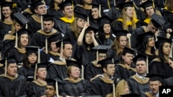 FILE - Students wait to be called for their degree during the University of Connecticut's Graduate School commencement ceremony.