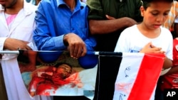 2013年7月9日，埃及被罢黜总统穆尔西的支持群众在开罗郊区纳赛尔城共和国卫队营地外面，举着在与安全部队冲突中一名被打死男子的照片。