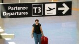 A passenger wearing a protective face mask walks at Fiumicino Airport 