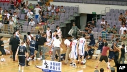 Basketball players from Georgetown University in Washington DC and China's Bayi team trade punches during their friendly game at the National Olympic Sports Center Gymnasium in Beijing, August 18, 2011