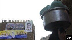 A woman walks near an election poster of Egypt's Muslim Brotherhood "The Freedom and Justice Party'" in the old city of Cairo December 2, 2011.
