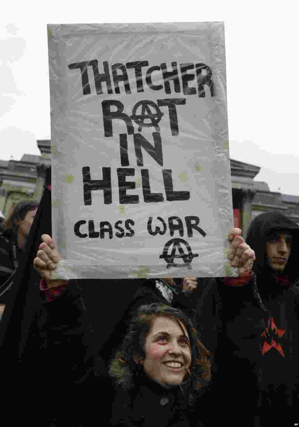 Seorang pengunjuk rasa memegang plakat dalam sebuah pesta untuk memperingati meninggalnya mantan PM Inggris Margaret Thatcher di lapangan Trafalgar, London, 13 April 2013.