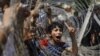 An Egyptian boy peers out of barbed wire during a protest in front of the Supreme Constitutional Court in Cairo, Egypt, Thursday June 14, 2012.