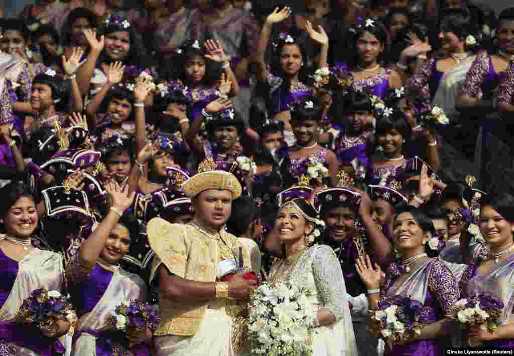 Sri Lankan couple Nisansala and Nalin smile with their bridesmaids and best men during their wedding ceremony as they break the Guinness record for a wedding with the most bridesmaids for a bride in Negombo November 8