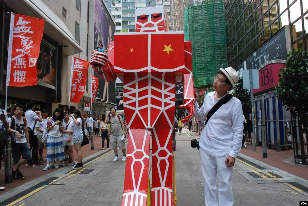 黄国才2013年参与七一大游行，他当年制作了一个概念来自日本漫画、9呎高、全身红色的'进击的共人'纸制机械人， 代表一股很强大的、具有摧毁性的力量进击香港（美国之音/汤惠芸）(photo:VOA)