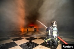 A Paris fire brigade member sprays water on flames inside the Notre Dame-Cathedral, in this image provided by the Paris Fire Brigade, after a fire broke out, in Paris, France, April 15, 2019.