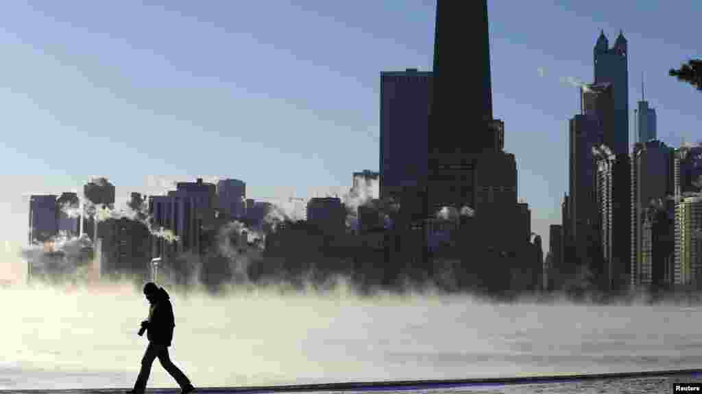 A man is silhouetted against the arctic sea smoke rising off Lake Michigan in Chicago, Illinois, Jan. 6, 2014. 