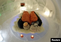 A couple are snug inside a sleeping bag during a photo opportunity at an ice hotel at Alpha Resort Tomamu's ice village in Shimukappu town, Japan's northern island of Hokkaido February 6, 2008.