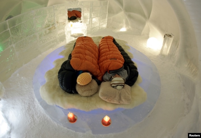 A couple are snug inside a sleeping bag during a photo opportunity at an ice hotel at Alpha Resort Tomamu's ice village in Shimukappu town, Japan's northern island of Hokkaido February 6, 2008.