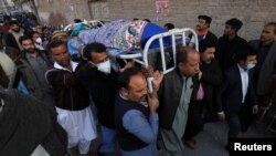 Men carry the body of priest William Siraj, who, according to police, was killed by unknown armed men in Peshawar, Pakistan, Jan. 30, 2022. 