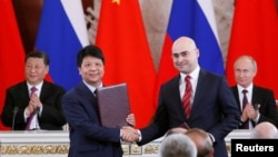 资料照：华为轮值董事长郭平2019年6月5日在中俄领导人习近平和普京的见证下代表华为与俄罗斯签下5G合同。