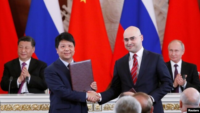 资料照：华为轮值董事长郭平2019年6月5日在中俄领导人习近平和普京的见证下代表华为与俄罗斯签下5G合同。